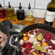 Oils and vinegars in glass bottles behind a stove with stew cooking